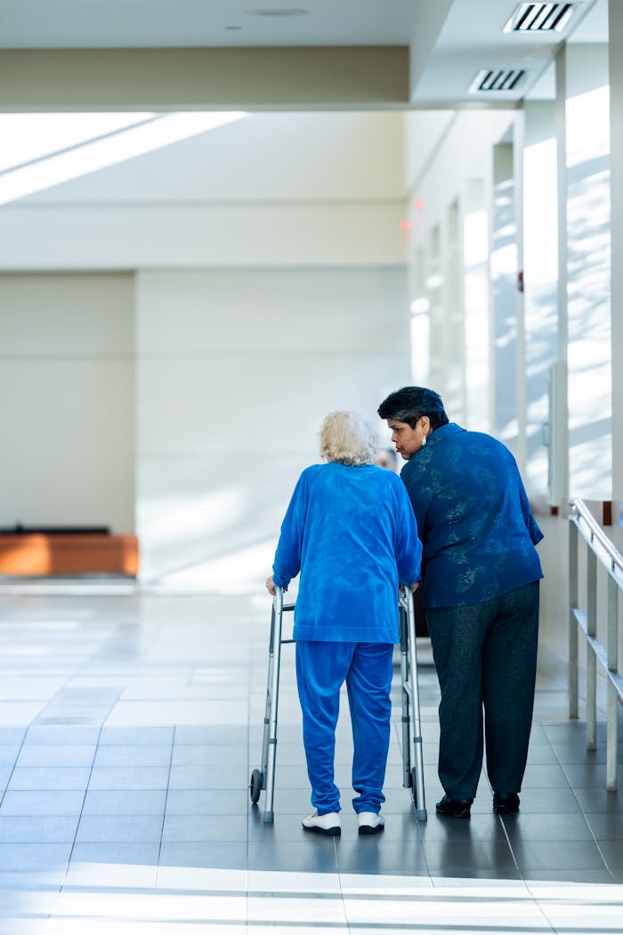The Art of Drawing Readers In: Your attractive post title goes here A nurse assists an elderly woman with a walker in a bright hospital corridor.